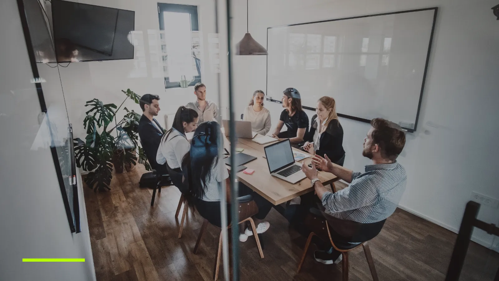 Marketing team meeting around a table in a glass-walled meeting room