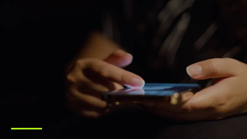 Mâini care derulează feedul de social media pe un smartphone