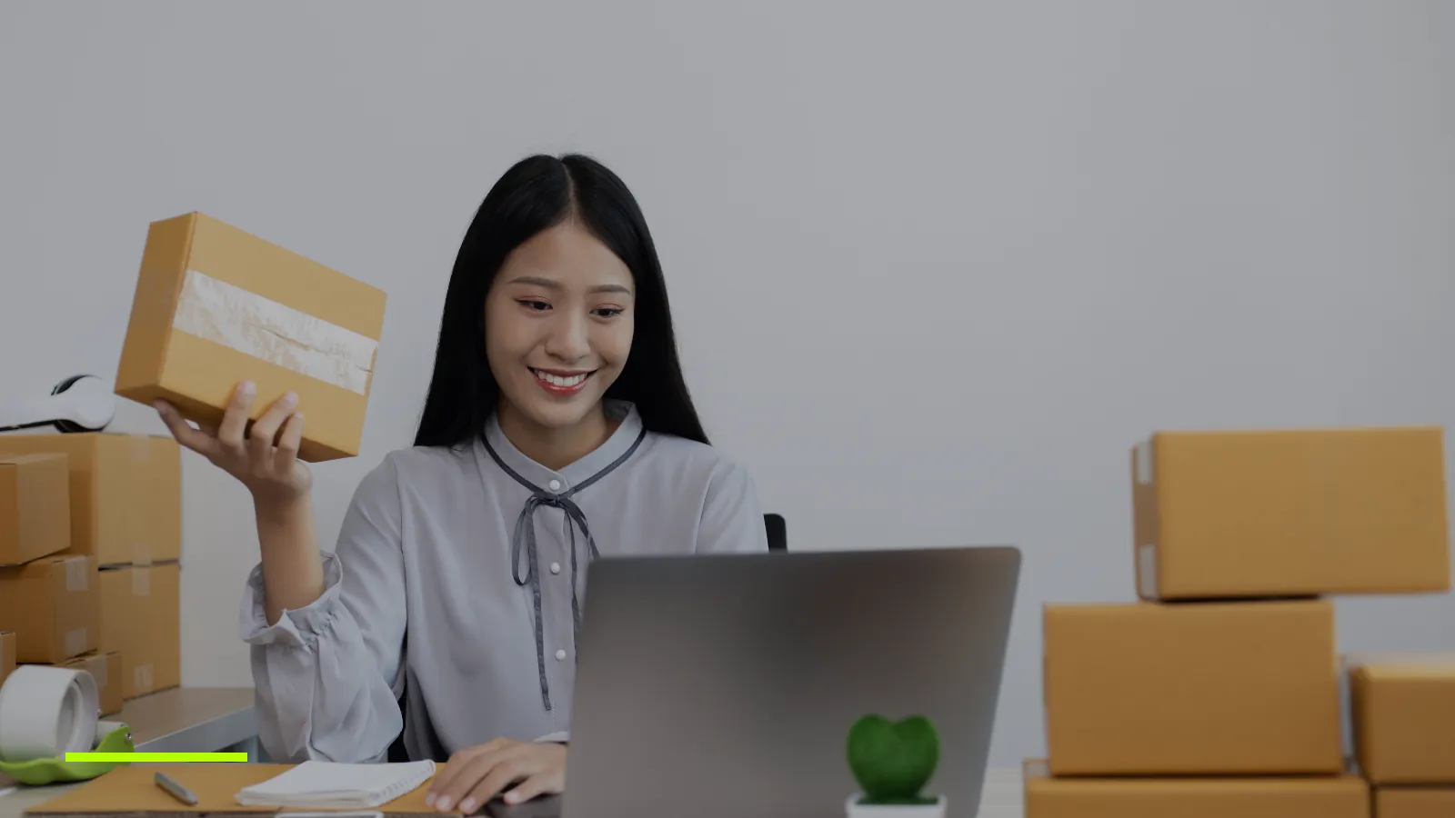 Online seller with parcels, working on a laptop