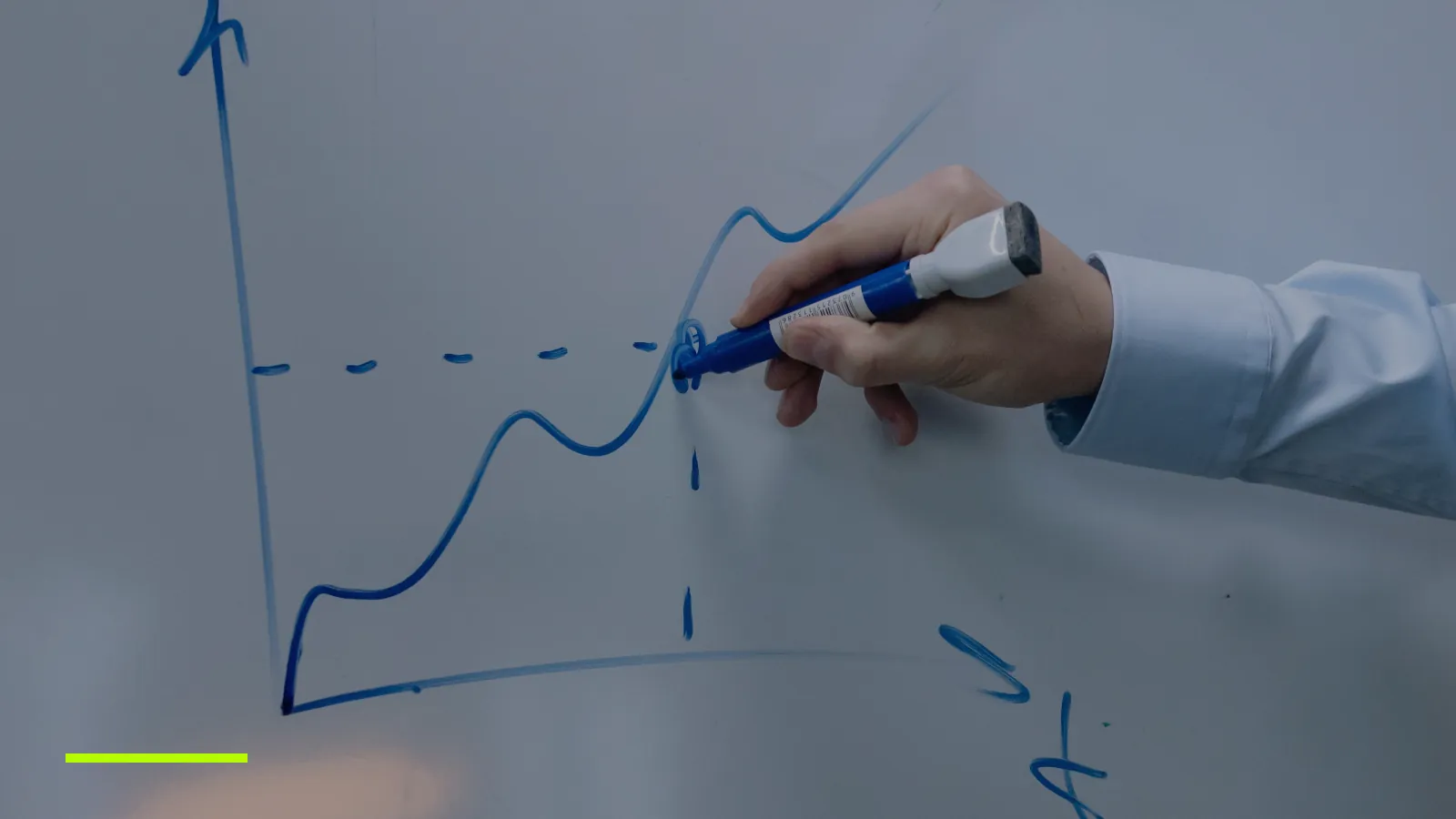 Hand drawing a rising line chart on a whiteboard